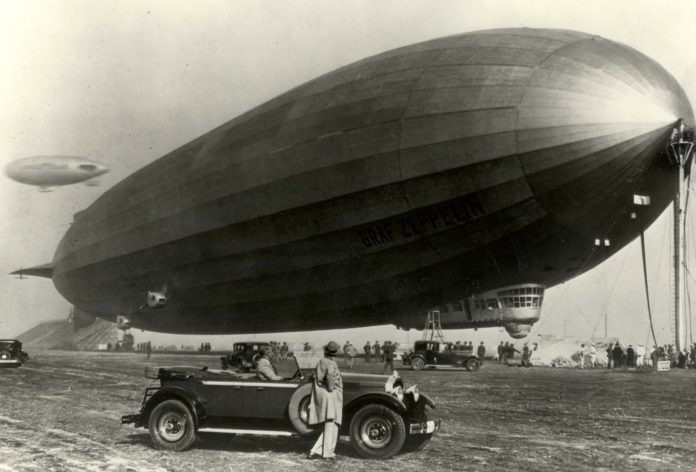 O dirixible Graf Zeppelin, cun Packard en primeiro termo.