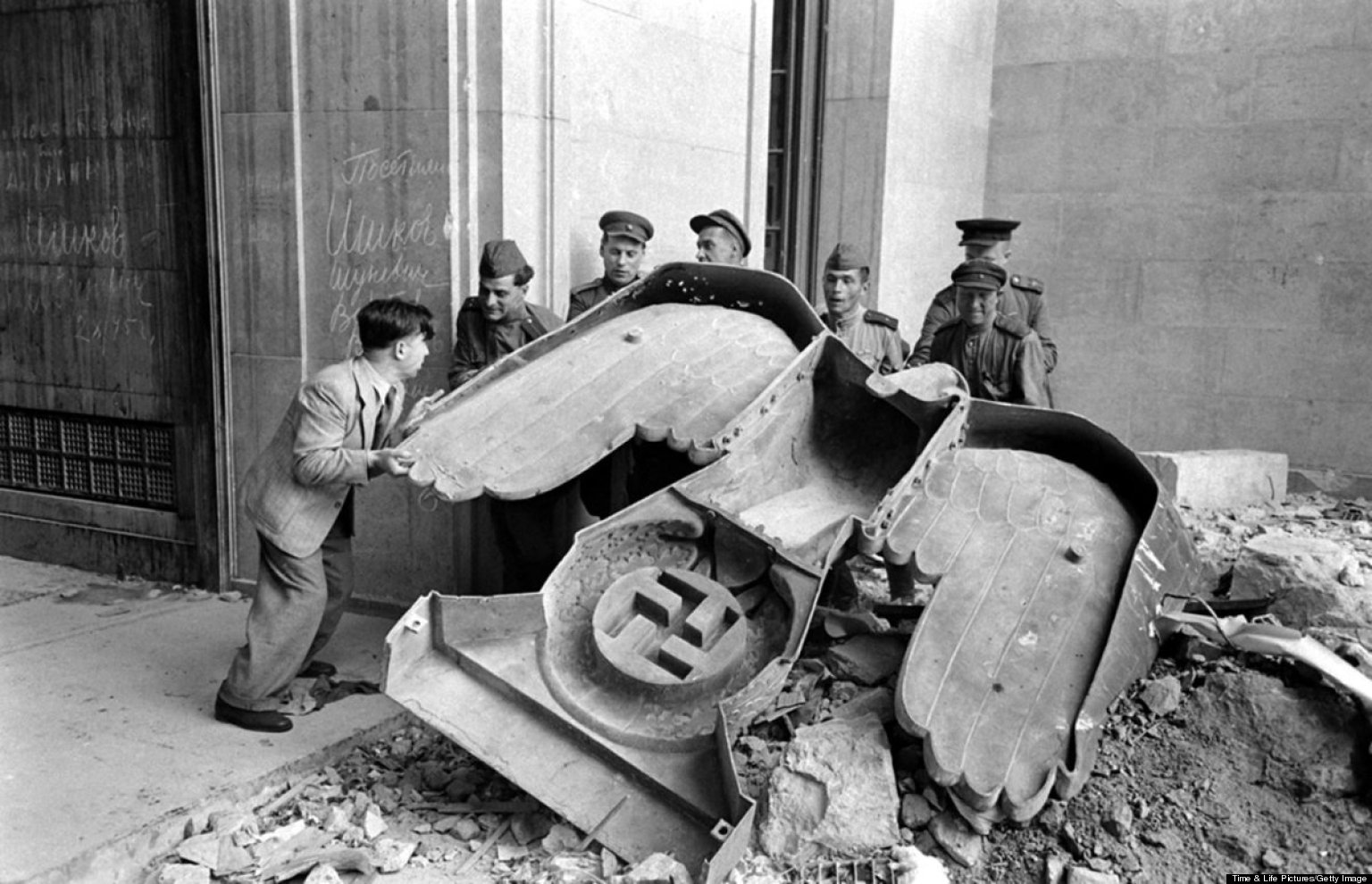 Soldados rusos desmontan un símbolo nazi en Berlín.