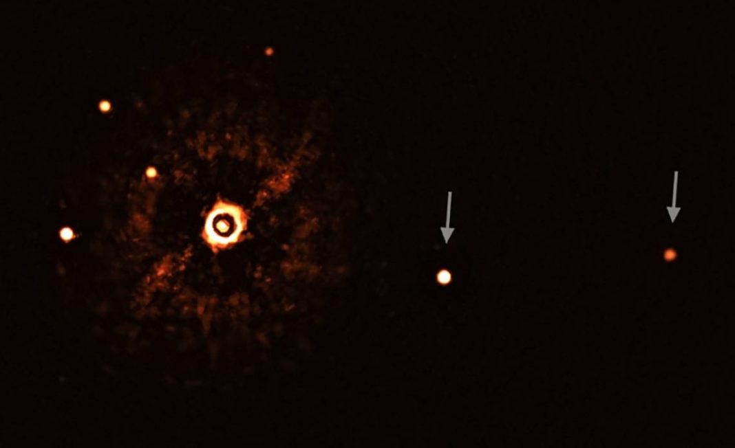 Estrela TYC 8998-760-1 (coa súa luz bloqueada) e os seus dous exoplanetas (marcados con frechas). Os outros puntos brillantes son estrelas de fondo. Fonte: ESO / Bohn  et al.