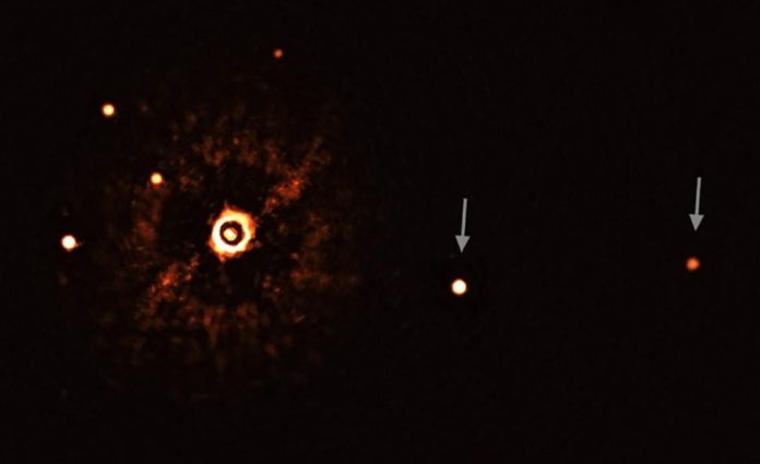 Estrela TYC 8998-760-1 (coa súa luz bloqueada) e os seus dous exoplanetas (marcados con frechas). Os outros puntos brillantes son estrelas de fondo. Fonte: ESO / Bohn et al.