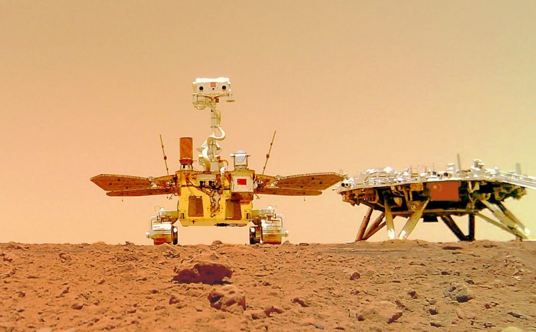 A sonda 'Tianwen', á dereita, e o vehículo 'Zhurong', no centro da imaxe, sobre a superficie do planeta vermello. Foto: CNSA.