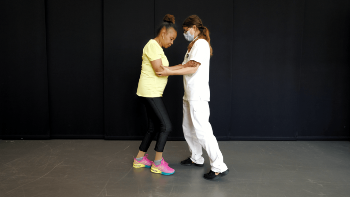 A paciente, que sofre atrofia multisistémica de tipo parkinsoniano, conseguio porse de pé e camiñar. Crédito: EPFL / Jimmy Ravier