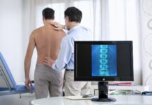Un doutor explora as costas dun paciente. Crédito: Shutterstock / Image Point Fr